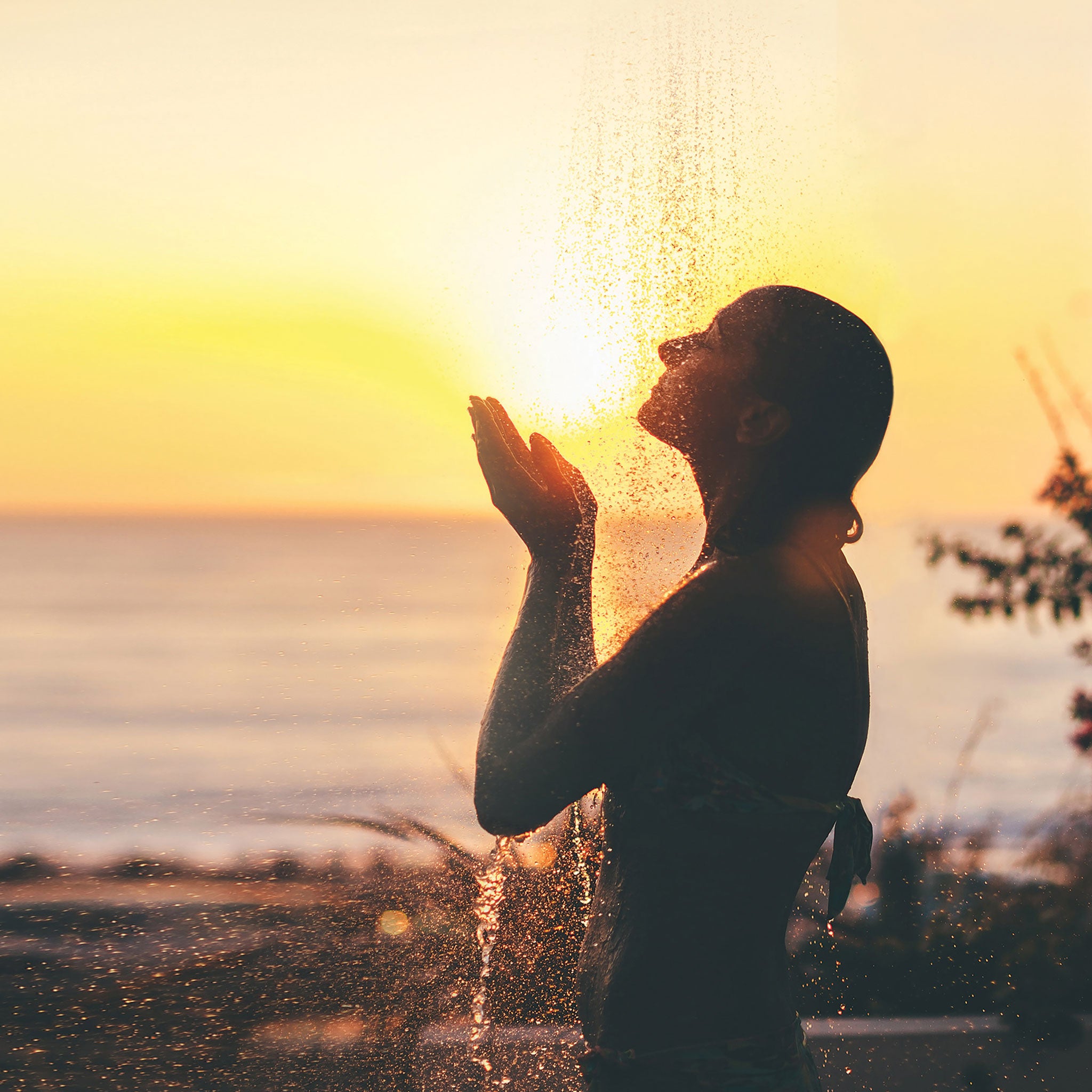 Lady taking outdoor shower at sunset