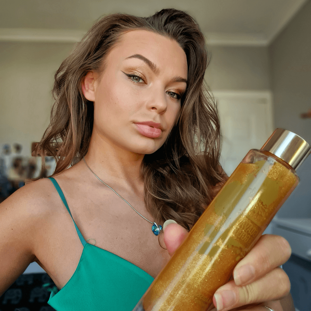 Lady holding Guava & Gold shimmering body oil