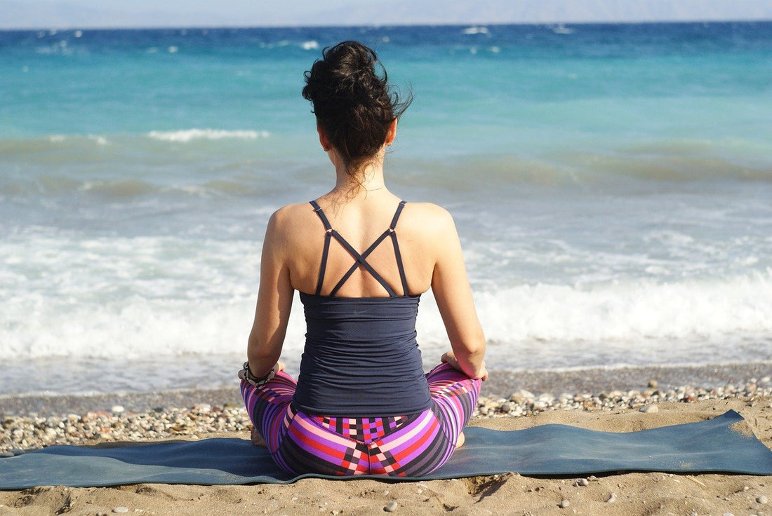Lady doing yoga on the beach